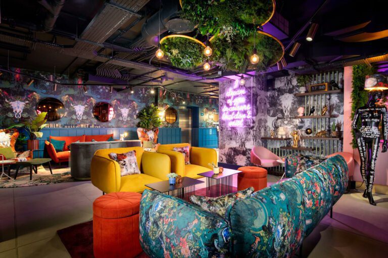 Example of strategic lighting design using yellow, pink, and blue tones to create a vibrant, multi-coloured ambience.
